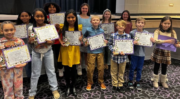 Fremont City Schools 3rd grade students in the Fremont Ross High School Performing Arts Center in front of the stage posing with awards.  