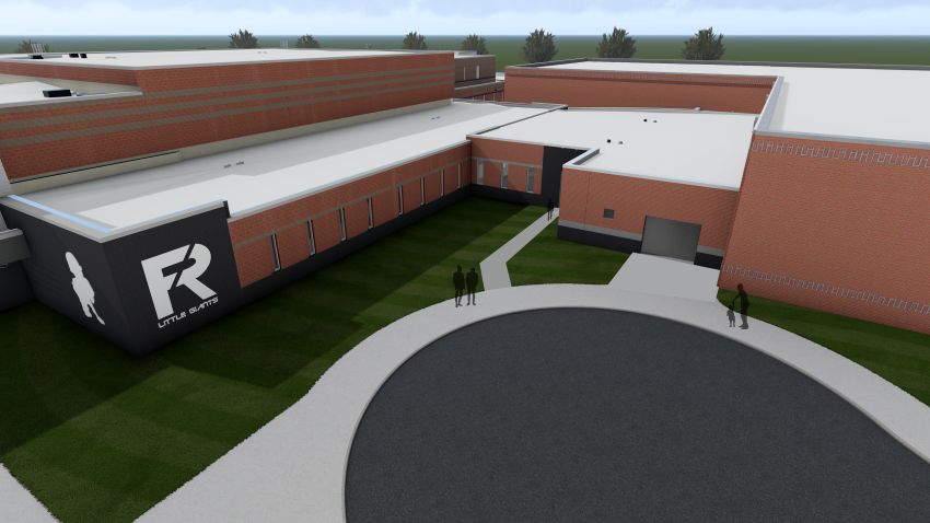 An aerial rendering looking down at the school complex from the northwest. It shows the flat white roofs of the new safety connector linking the high school and natatorium. The layout includes a circular drop-off loop, concrete pathways, and the distinct dark gray wall with the school's logo.